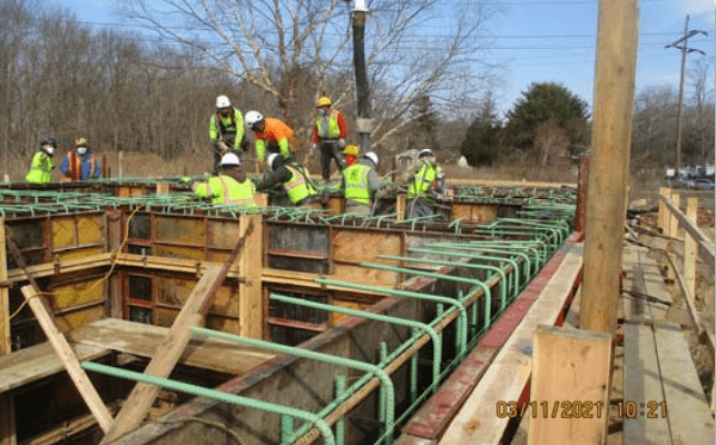 Construction workers assembling a concrete formwork at a construction site under construction management.