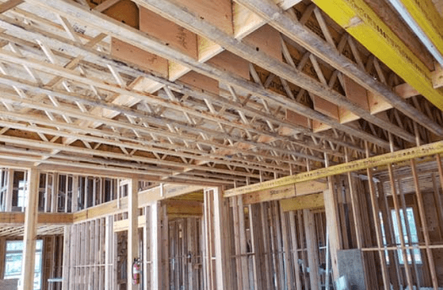 Interior view of a building design under construction showing wooden framing and trusses.