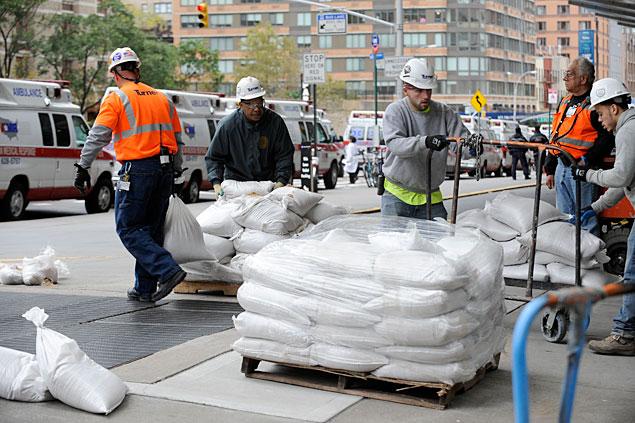 Workers preparing sandbags for flood prevention in an urban area under the guidance of JRH Holzmacher Engineering.
